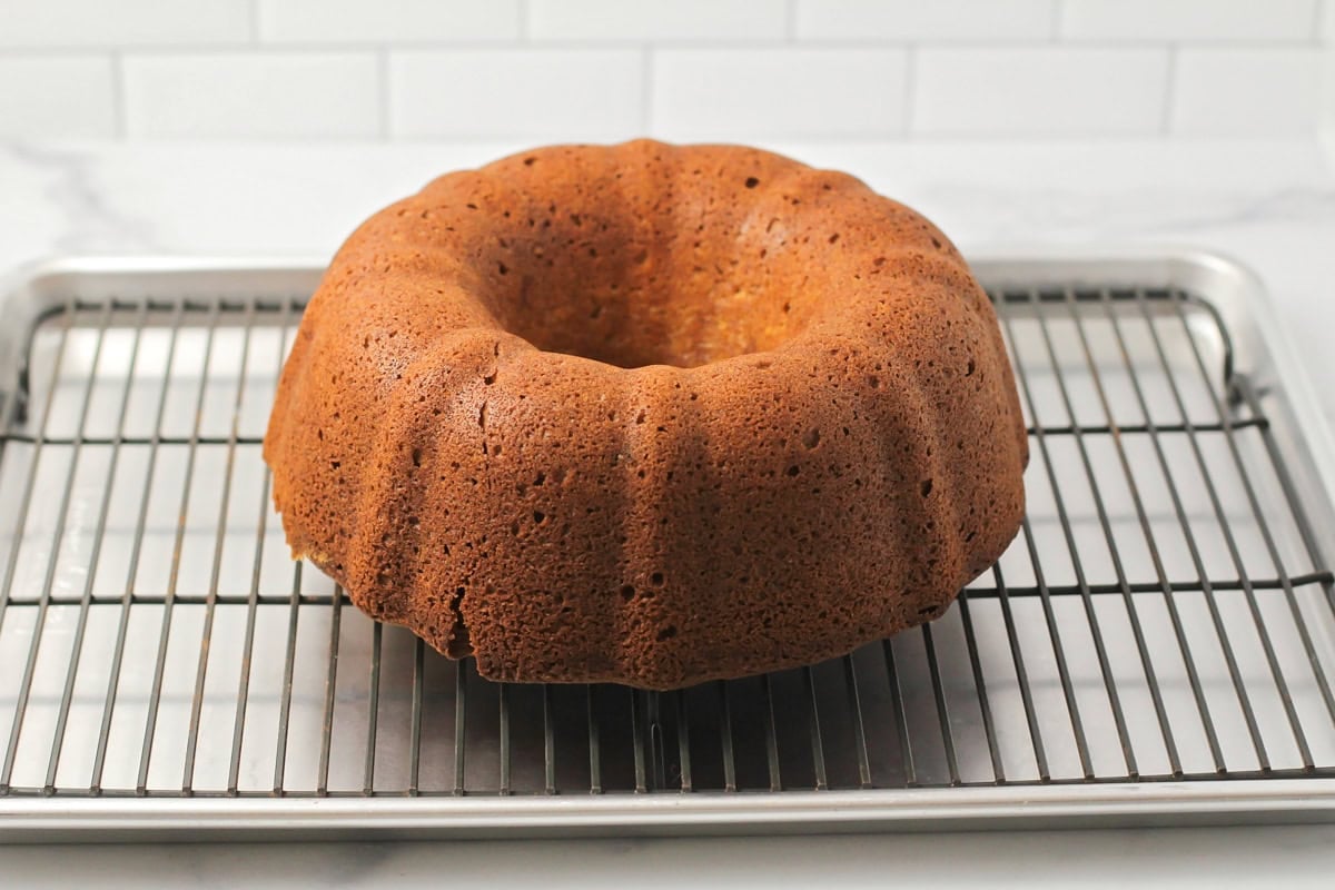 A bundt cake cooling on a wire rack.