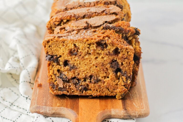 Sliced chocolate chip pumpkin bread on a cutting board.
