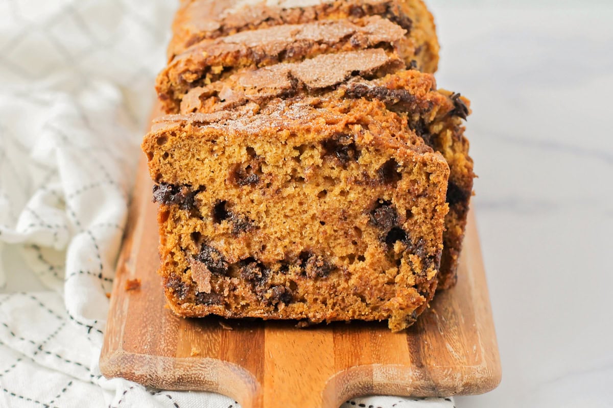 Sliced pumpkin chocolate chip bread on a cutting board.