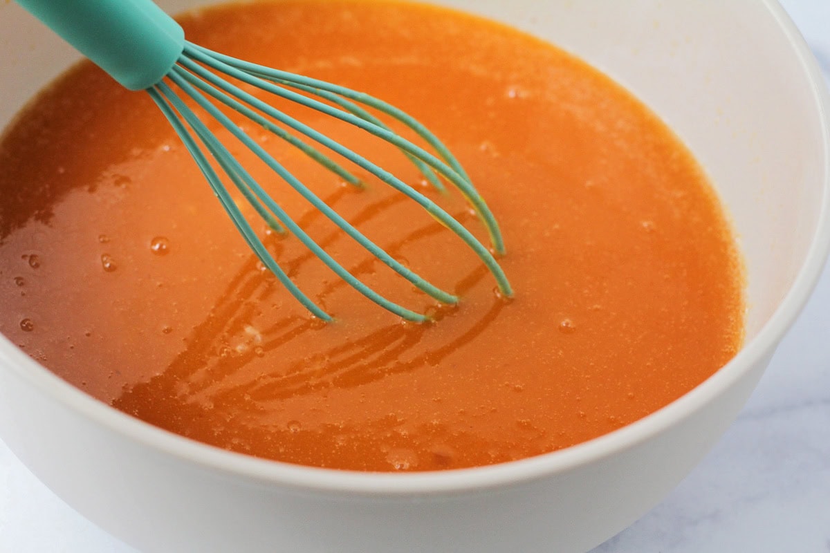 Whisking pumpkin puree and other ingredients in a bowl.