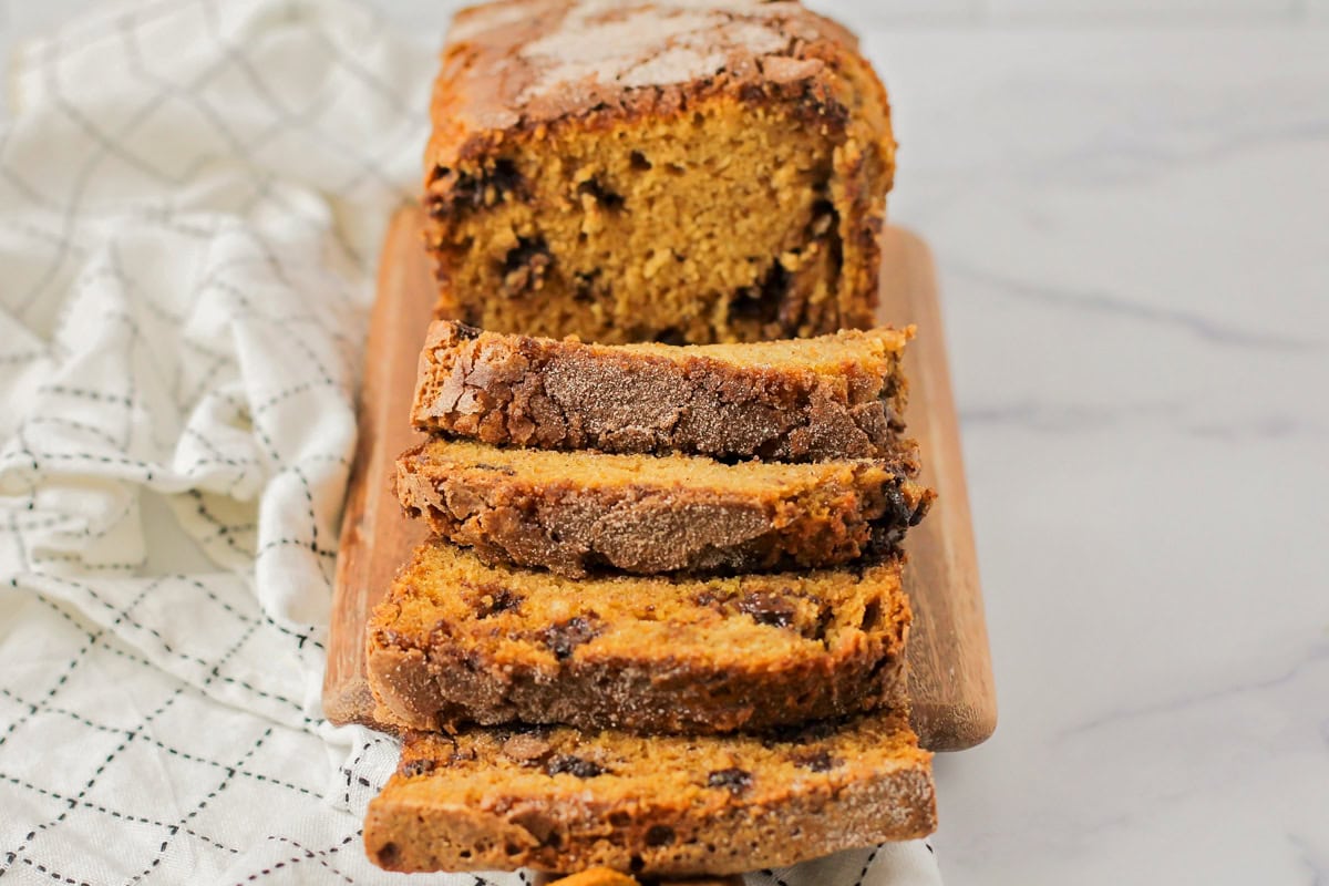 Pumpkin chocolate chip bread sliced on a cutting board.