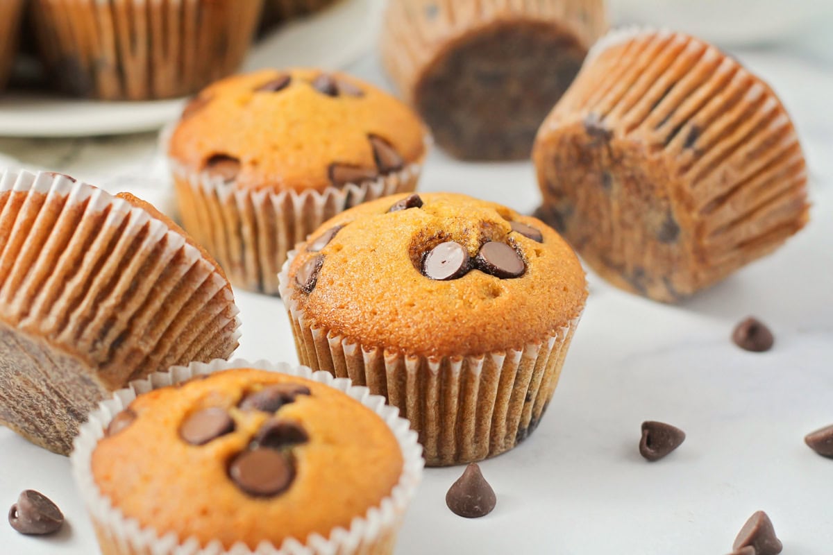 Close up of pumpkin chocolate chip muffins on a kitchen counter.