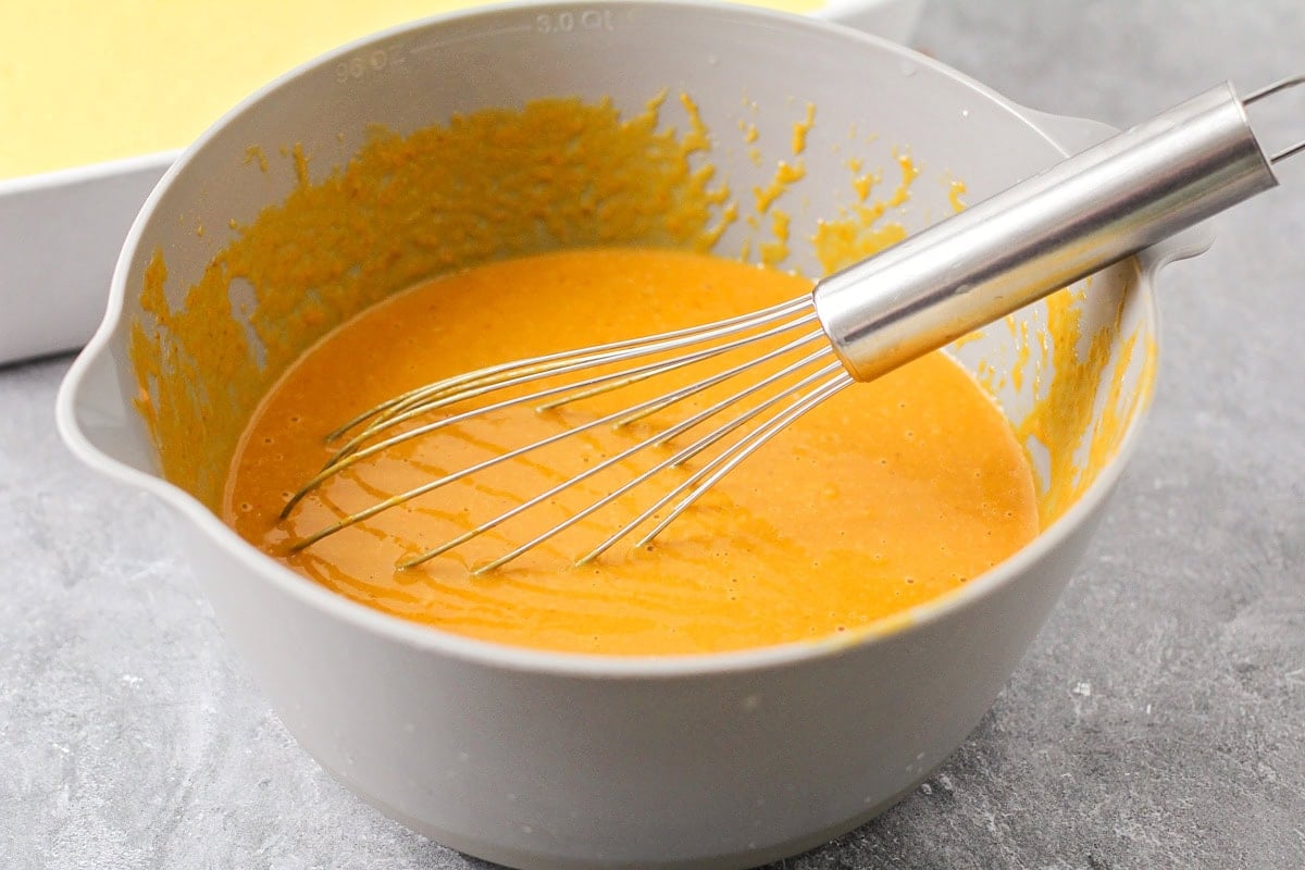 Pumpkin puree and other ingredients mixed together in bowl for Magic Pumpkin Cake recipe.