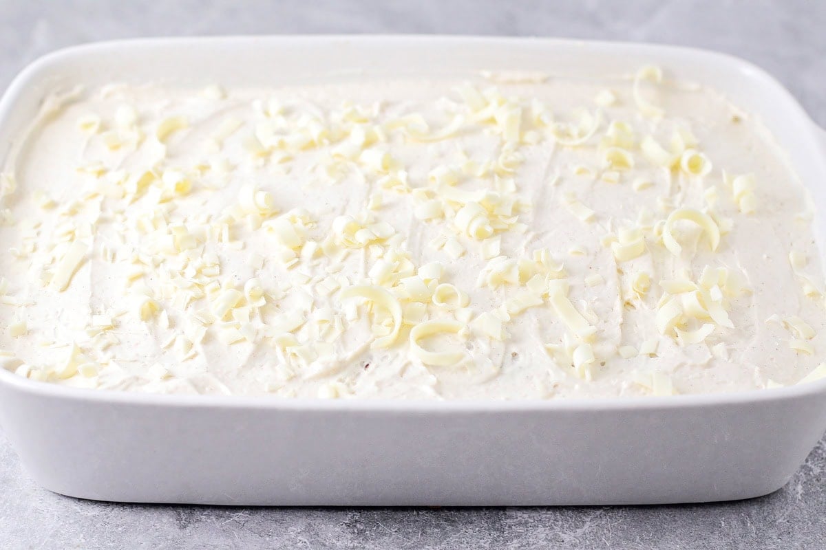 Frosting and white chocolate curls on top of pumpkin magic cake.