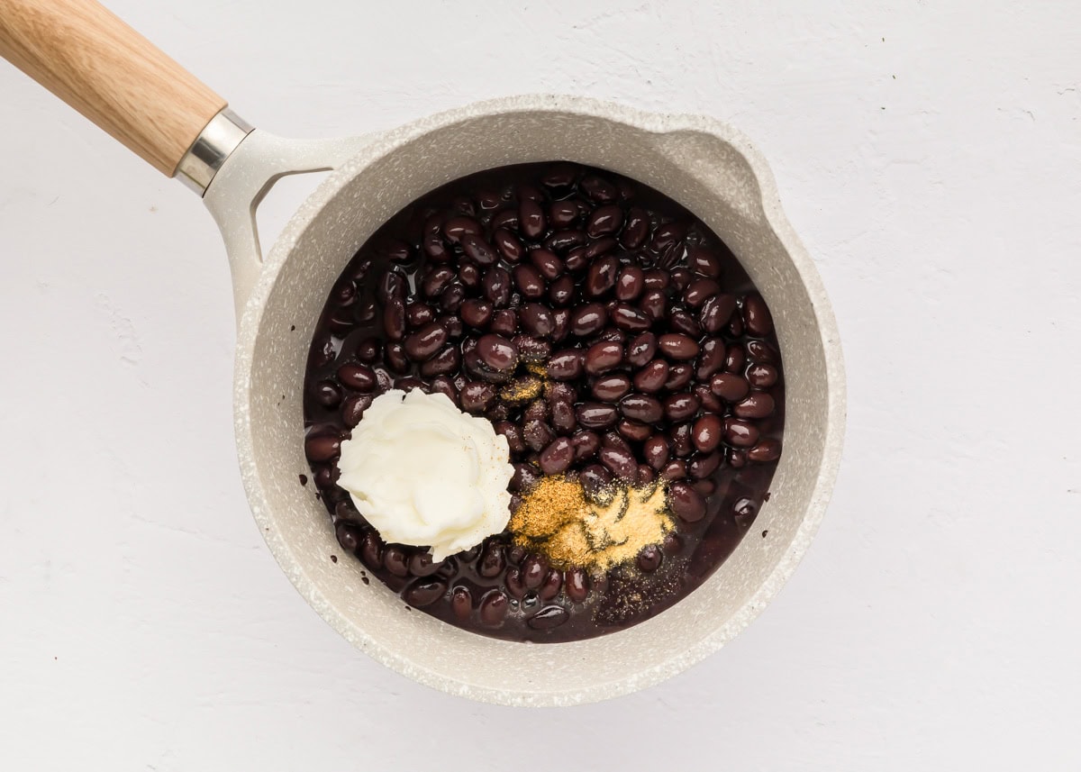 Black beans with shortening and seasonings in a pot.