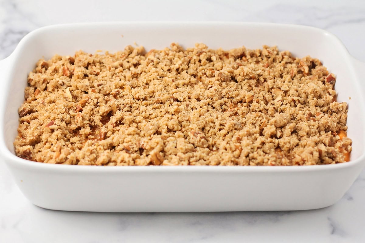 Sugar nut topping sprinkled on a baking dish of sweet potatoes.