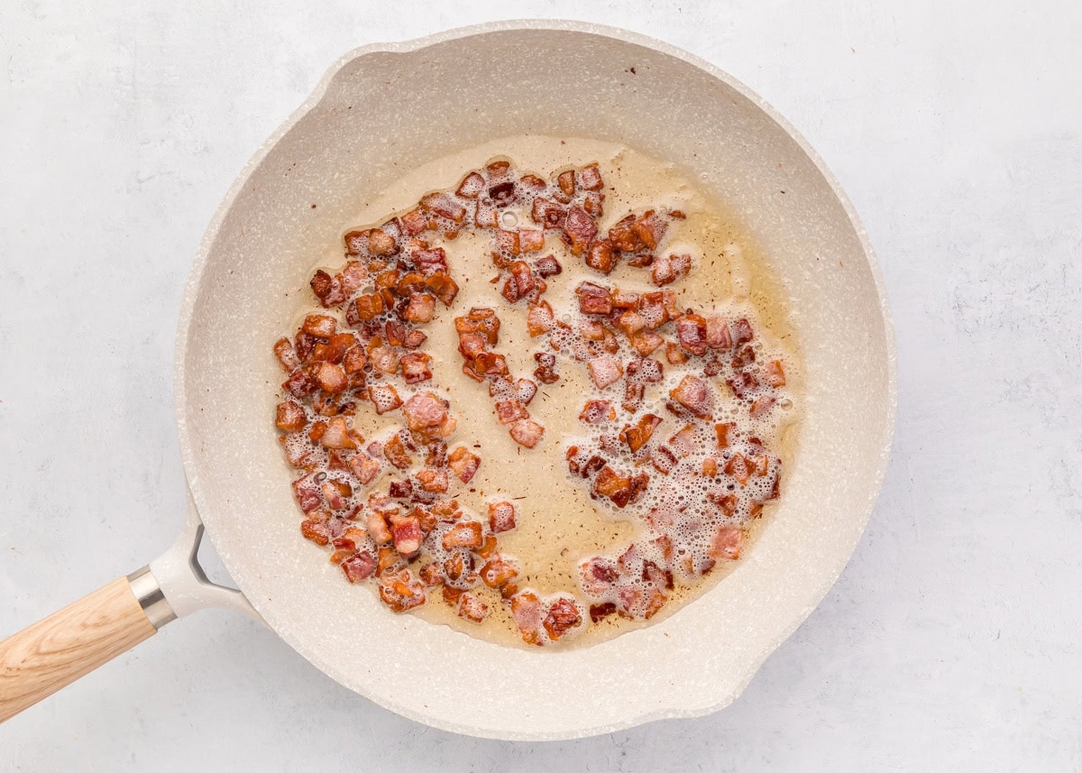 Bacon bits cooking in butter.