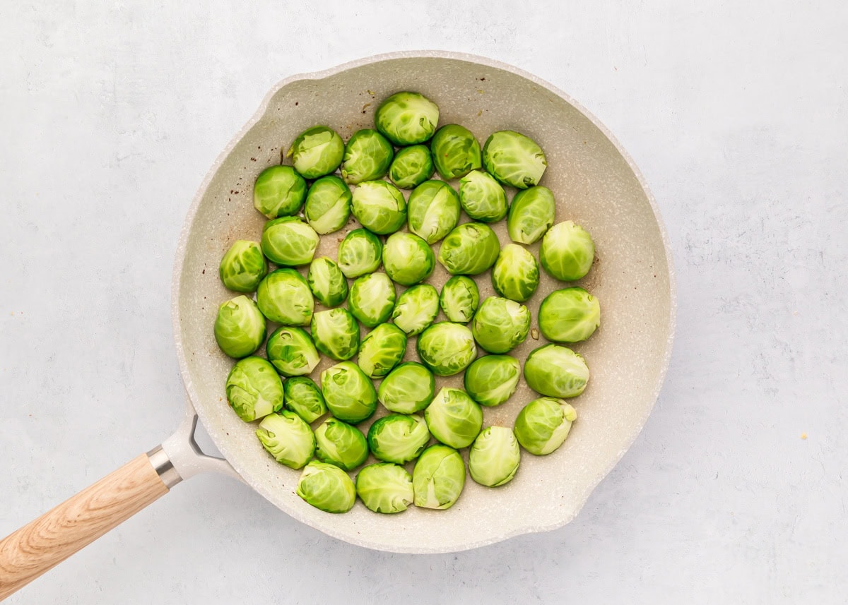 Halved Brussels sprouts in a skillet.