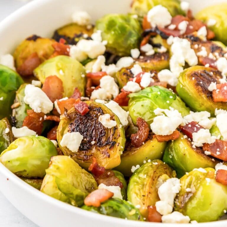 Thanksgiving Brussels Sprouts in bowl with bacon and cheese sprinkled on top.