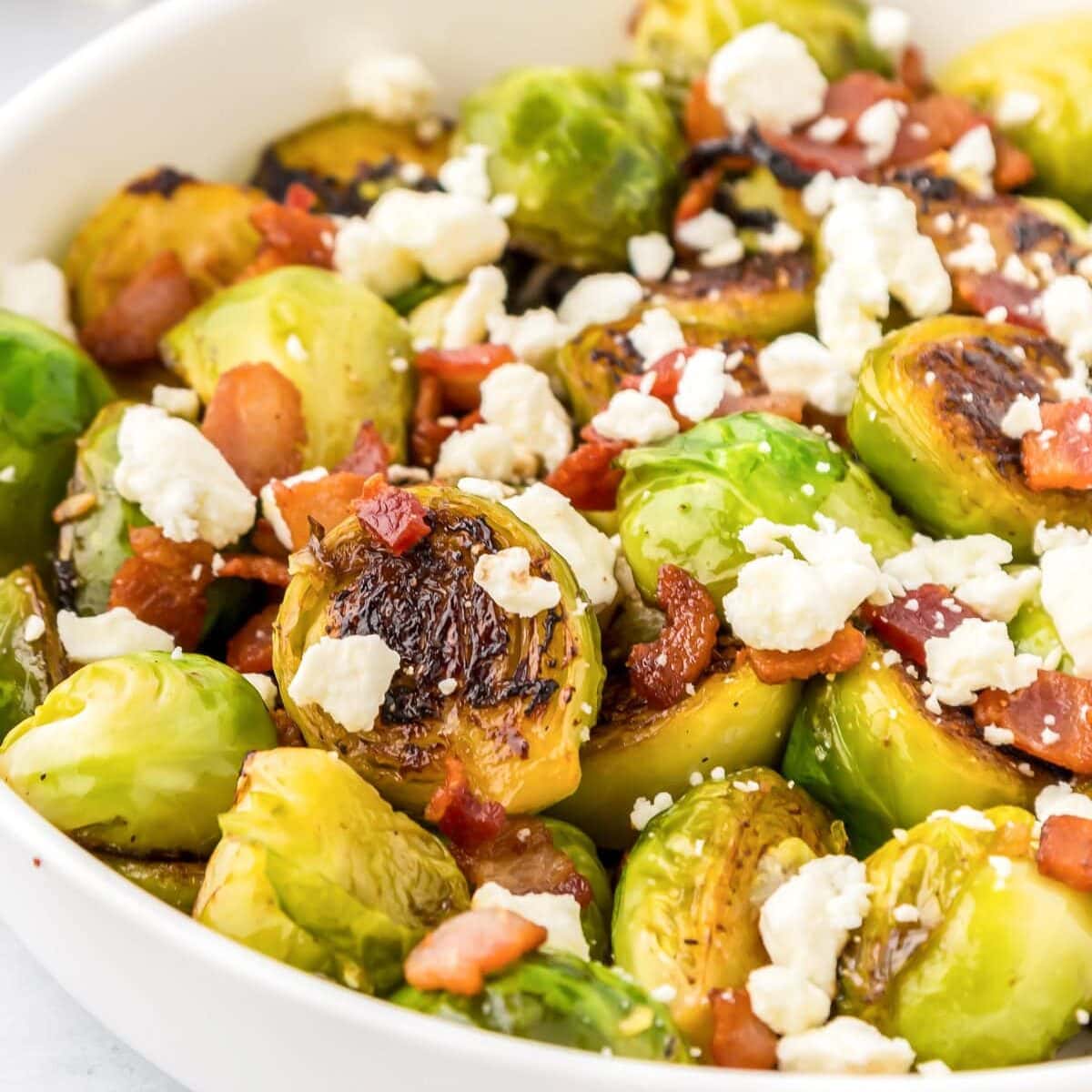 Close up of a white bowl filled with Thanksgiving Brussels sprouts.