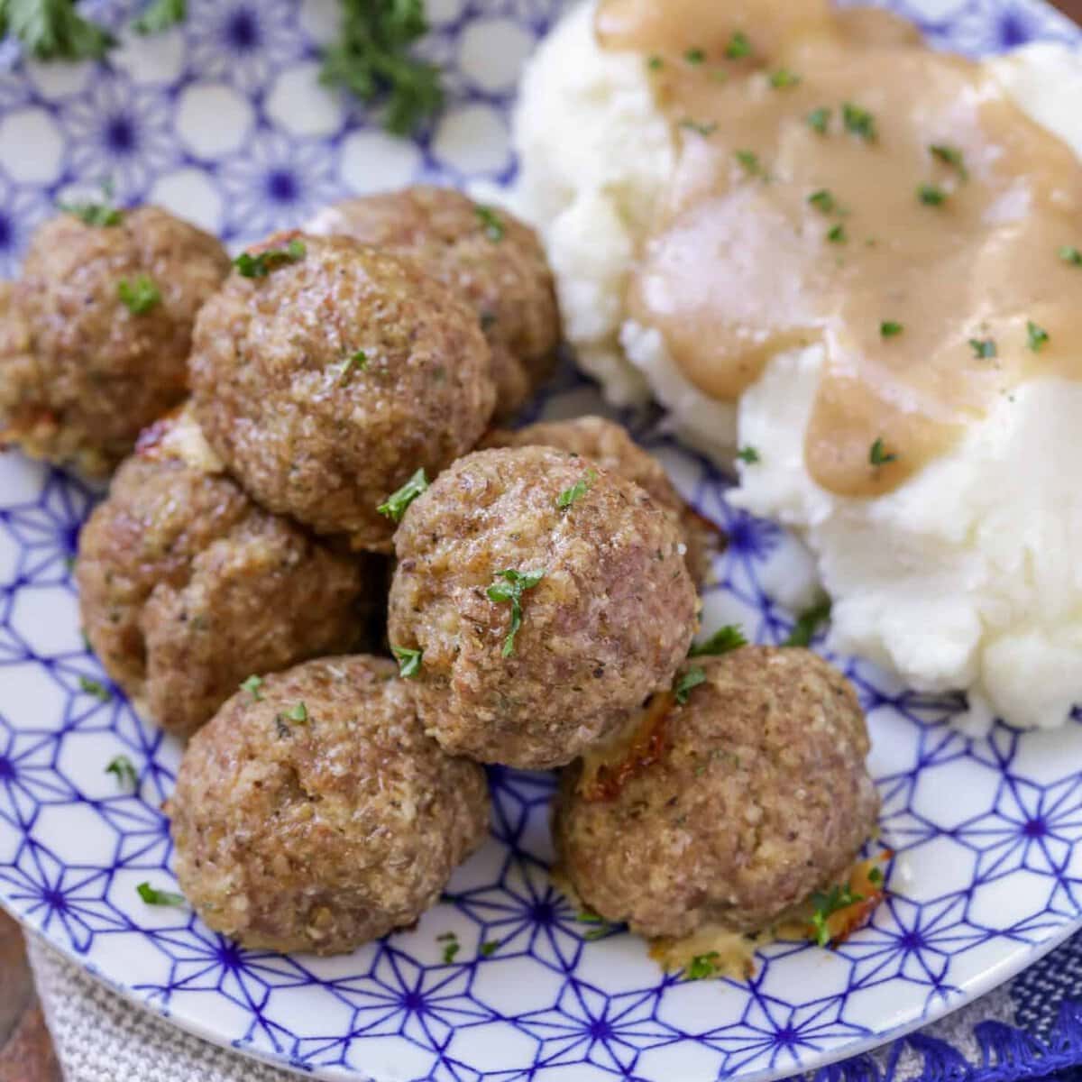 Turkey meatballs recipe with mashed potatoes on blue and white plate.