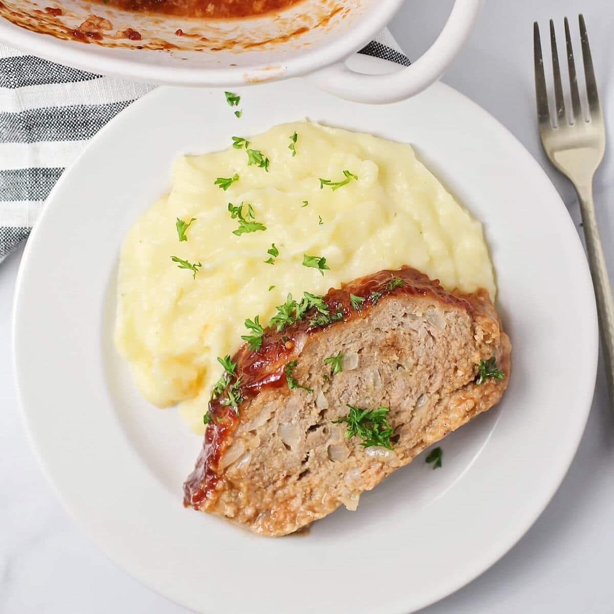 Top view of a slice of meatloaf served with a side of mashed potatoes.