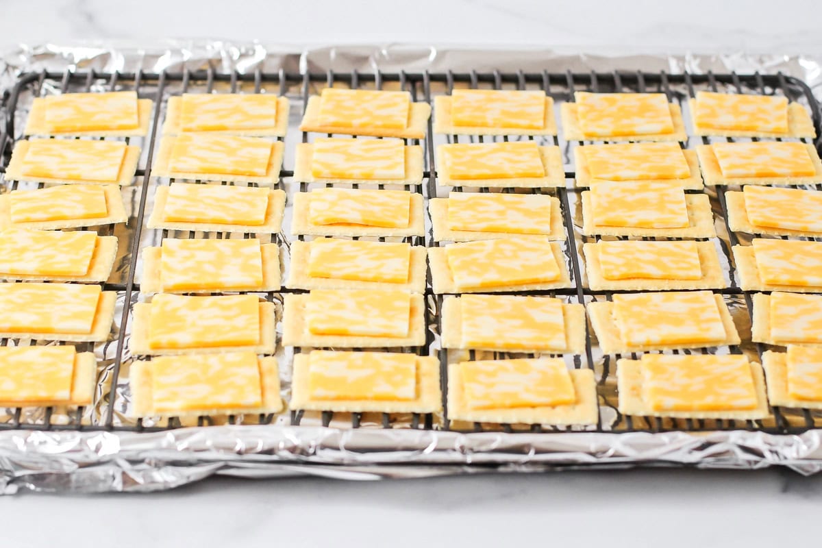 Adding cheese slices to the crackers.