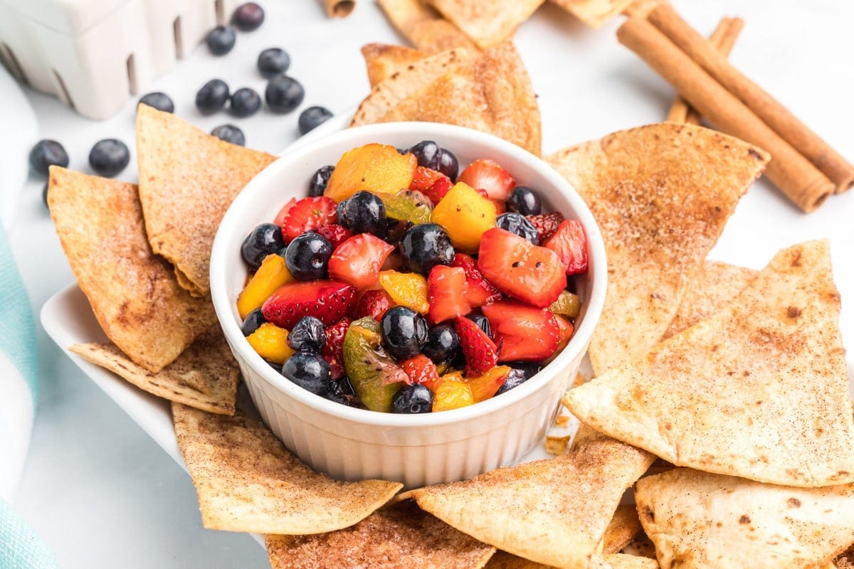 A ramiken of fruit salsa surrounded by homemade cinnamon tortilla chips. 