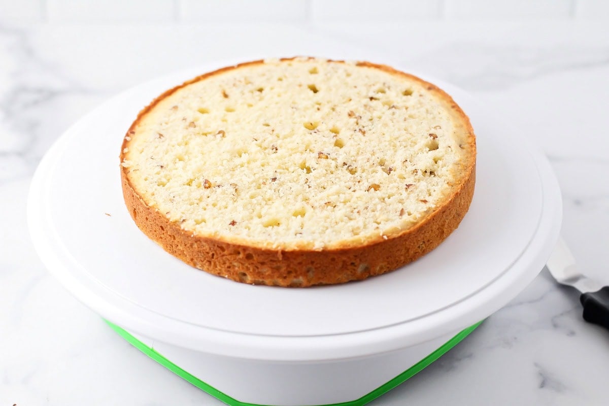 A cake round with the top sliced off on a cake plate.