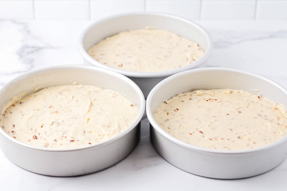 Three cake pans filled with cake batter.