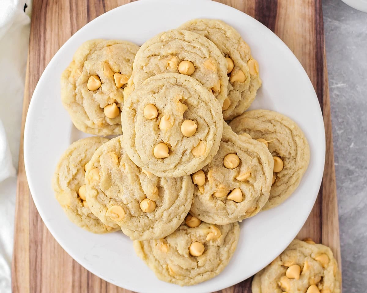 Butterscotch cookies stacked on plate on cutting board.