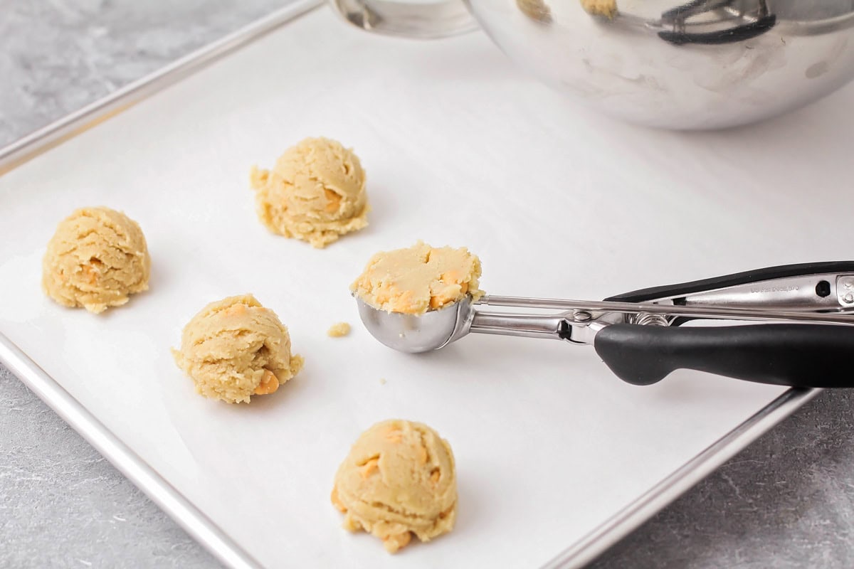 Scoops of butterscotch cookie dough on cookie sheet.