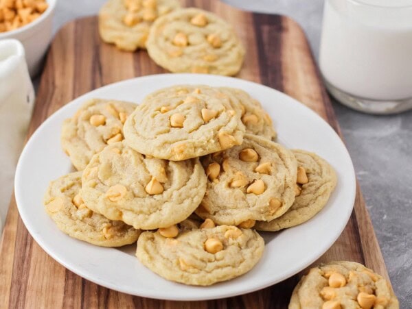 Butterscotch cookies stacked on top of each other on white plate.