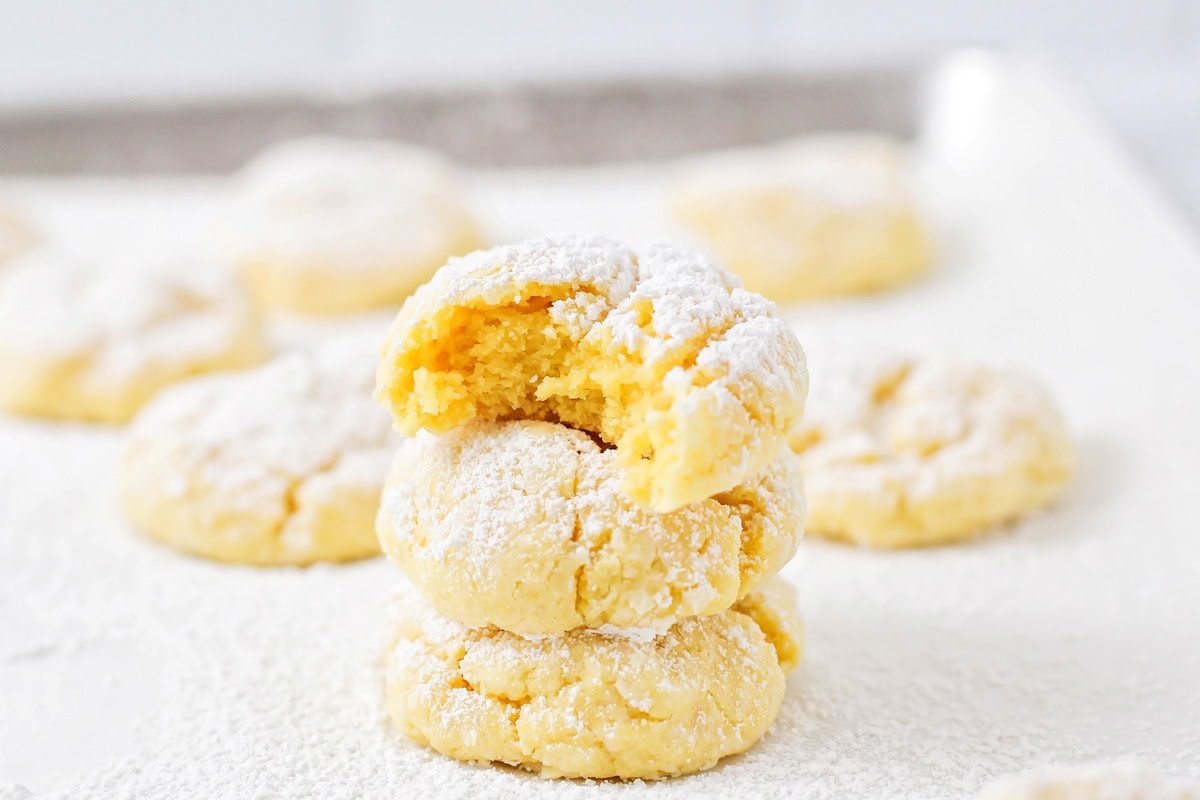 Cake mix cookies stacked with one bitten cookie on top.