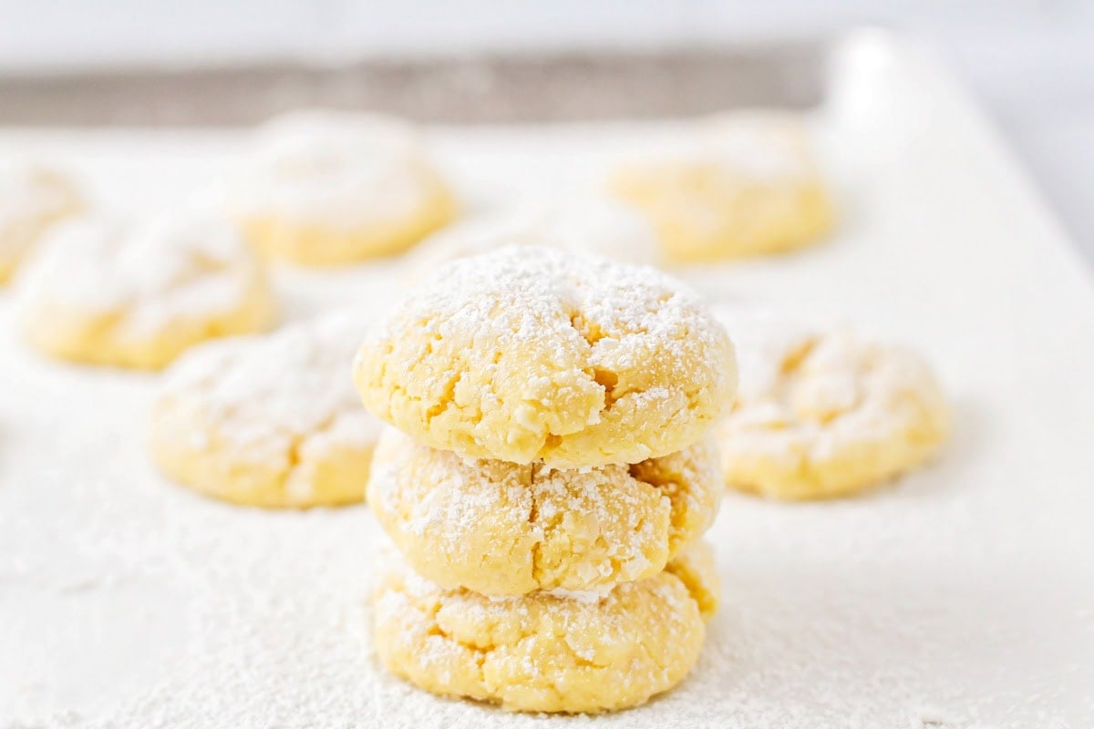 Three cake mix cookies stacked on a baking sheet.