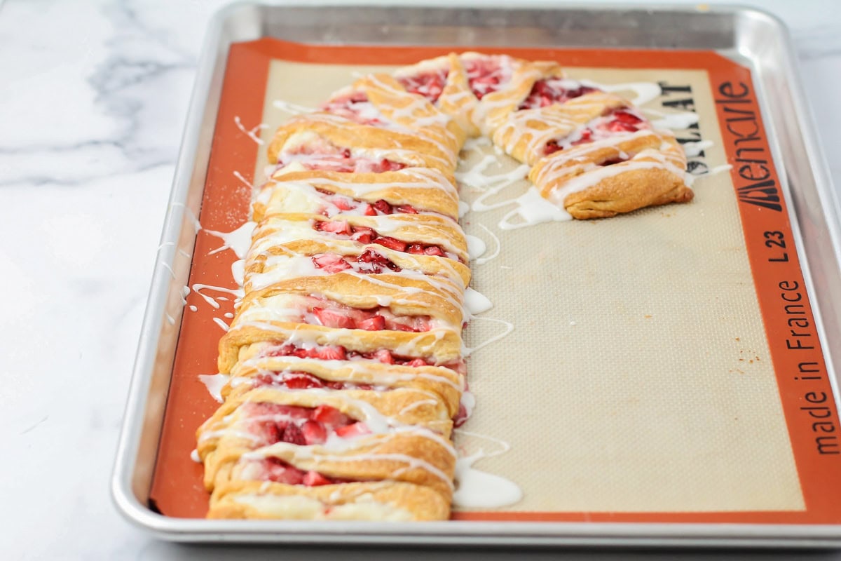 Close up of a baked candy cane Danish on a silpat mat.