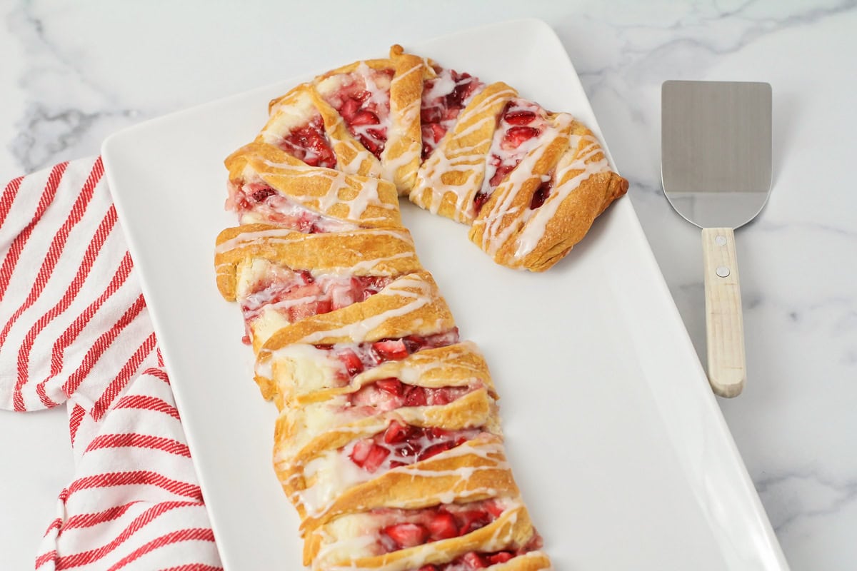 A candy cane danish on a white serving platter.