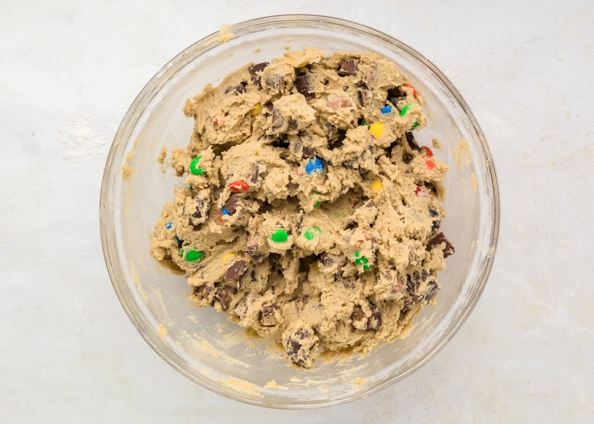 Candy cookie dough mixed together in glass bowl.