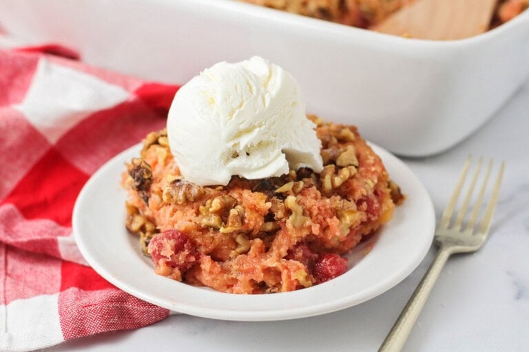 Cherry dump cake on plate with vanilla ice cream on top.