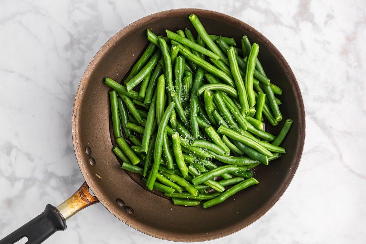 Green beans being cooked in skillet.