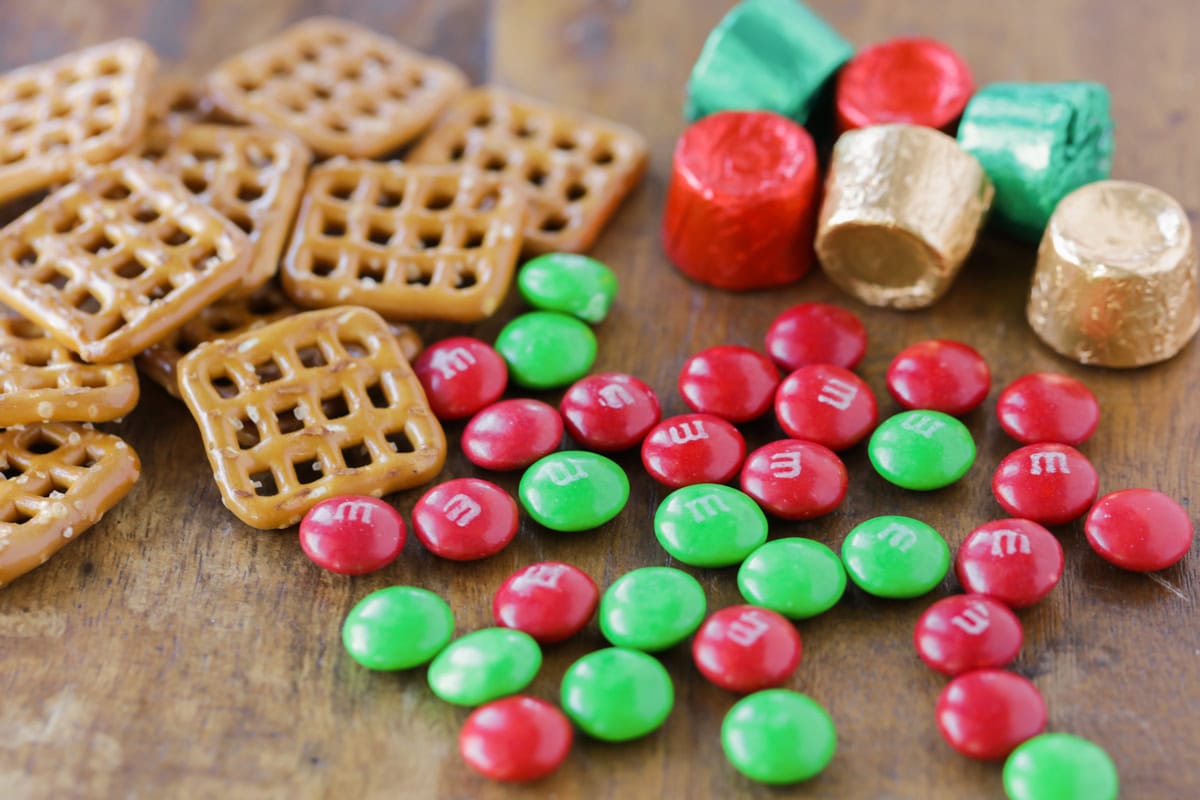 M&Ms, Rolos, and pretzels on a kitchen table.