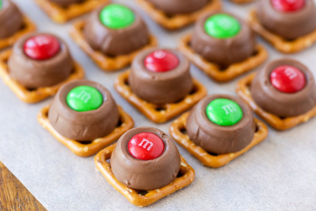 Close up of Christmas Rolo pretzels on a lined baking sheet.