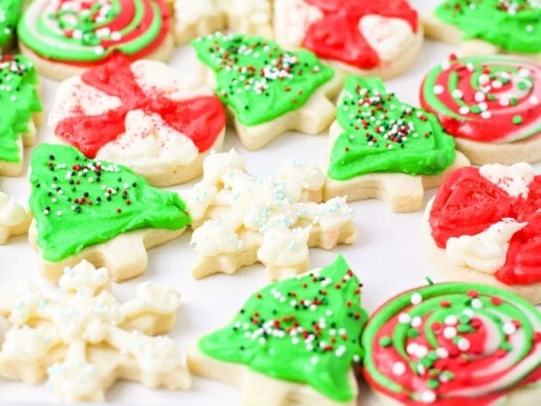 Multiple Christmas sugar cookies on parchment paper.
