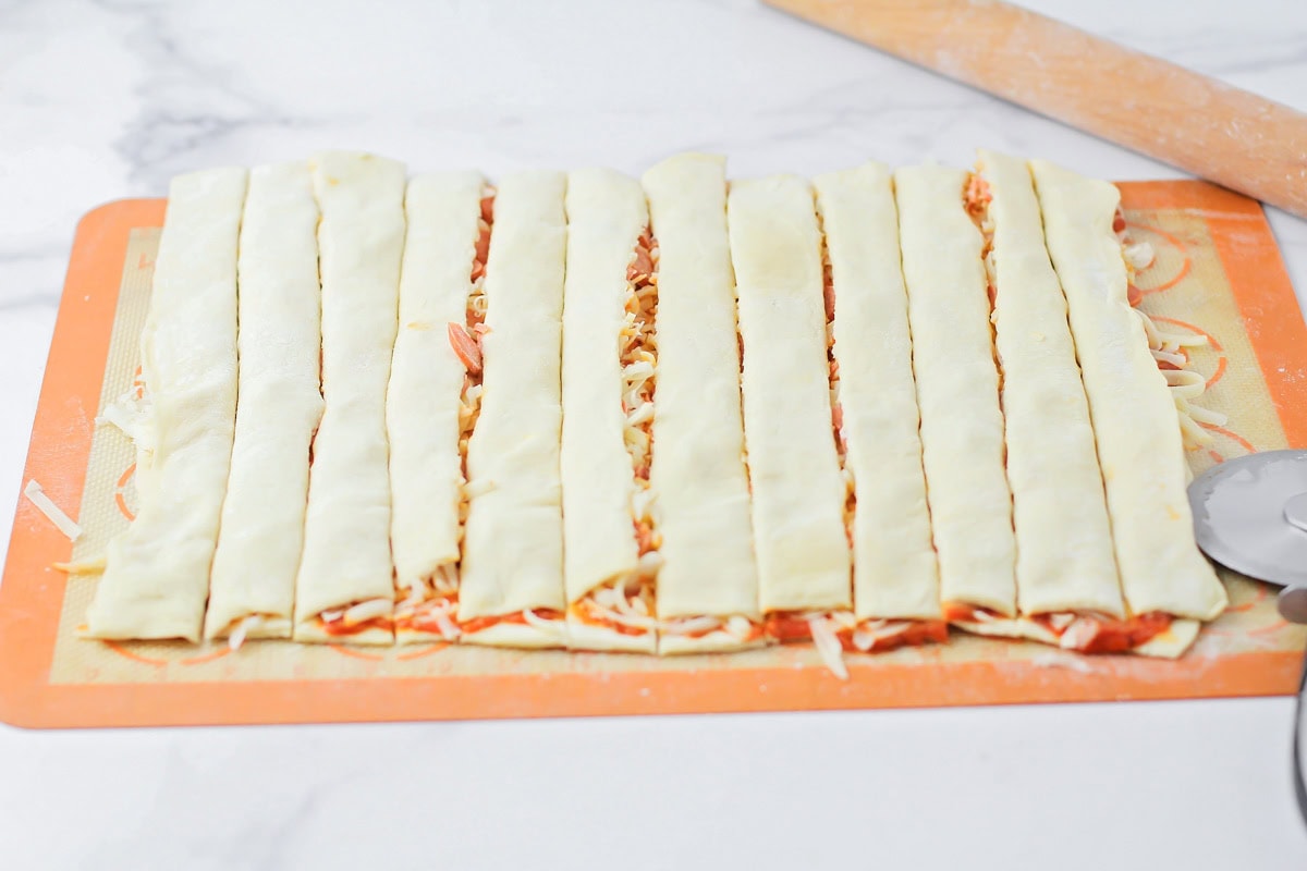 Cutting the puff pastry filled dough into strips.