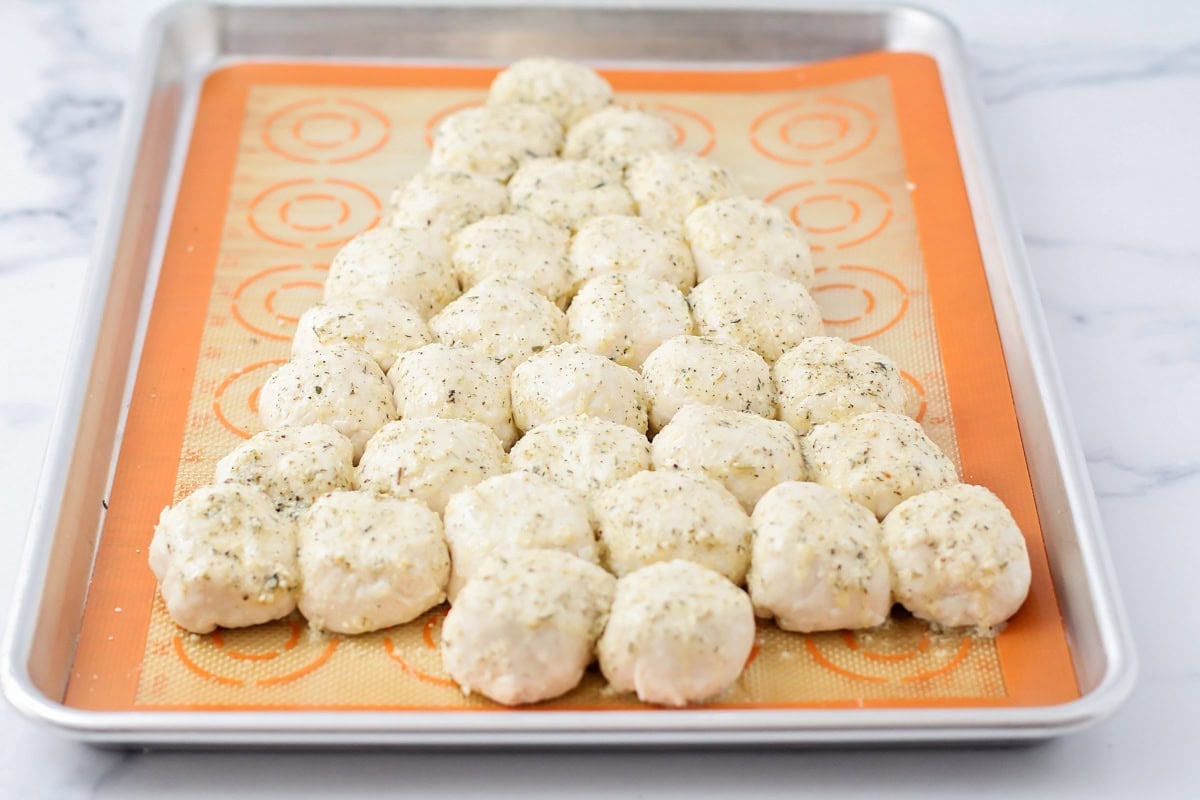 Dough balls shaped like a Christmas tree and covered in butter and seasonings.