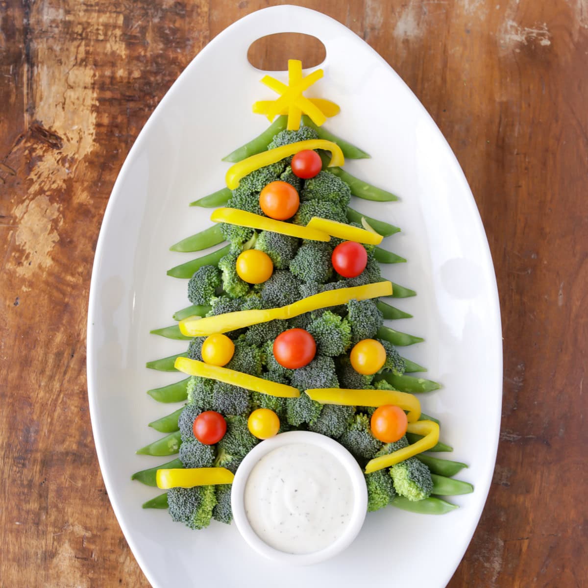 Christmas veggie tray shaped like a tree and served with dip.