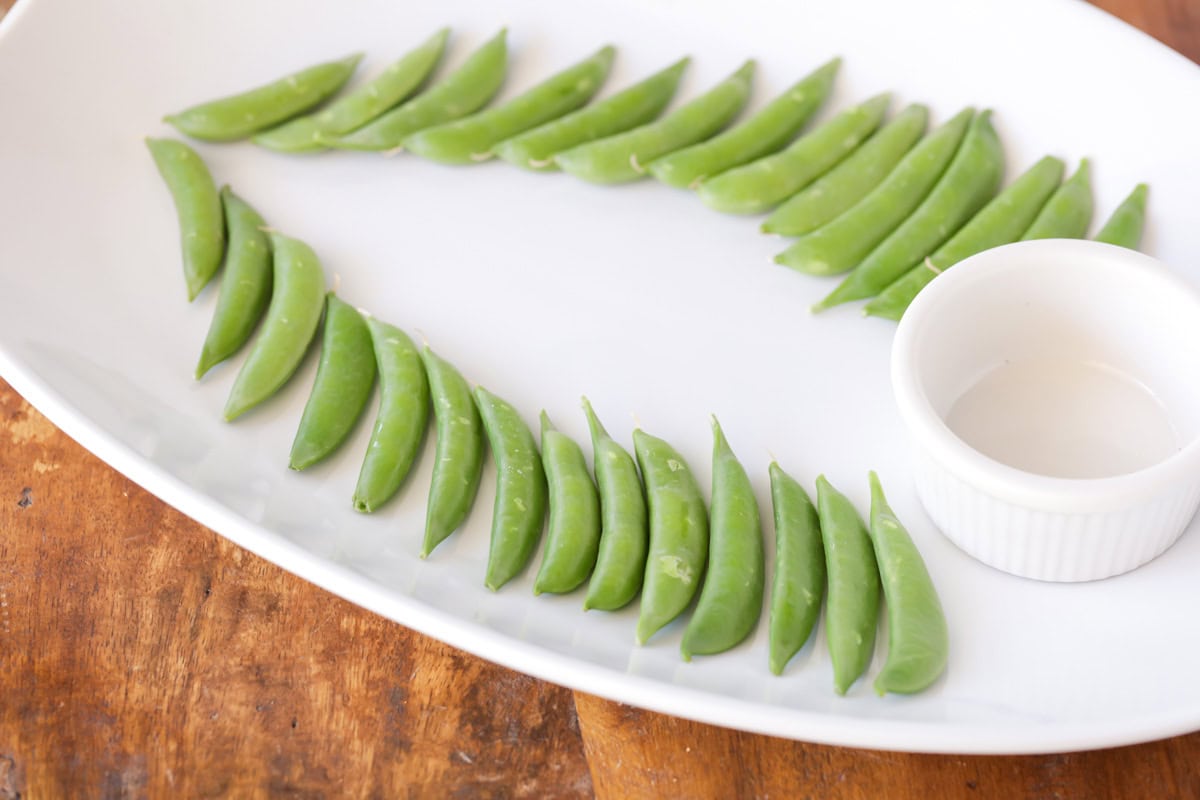 Lining peas in the shape of a Christmas tree on a platter.