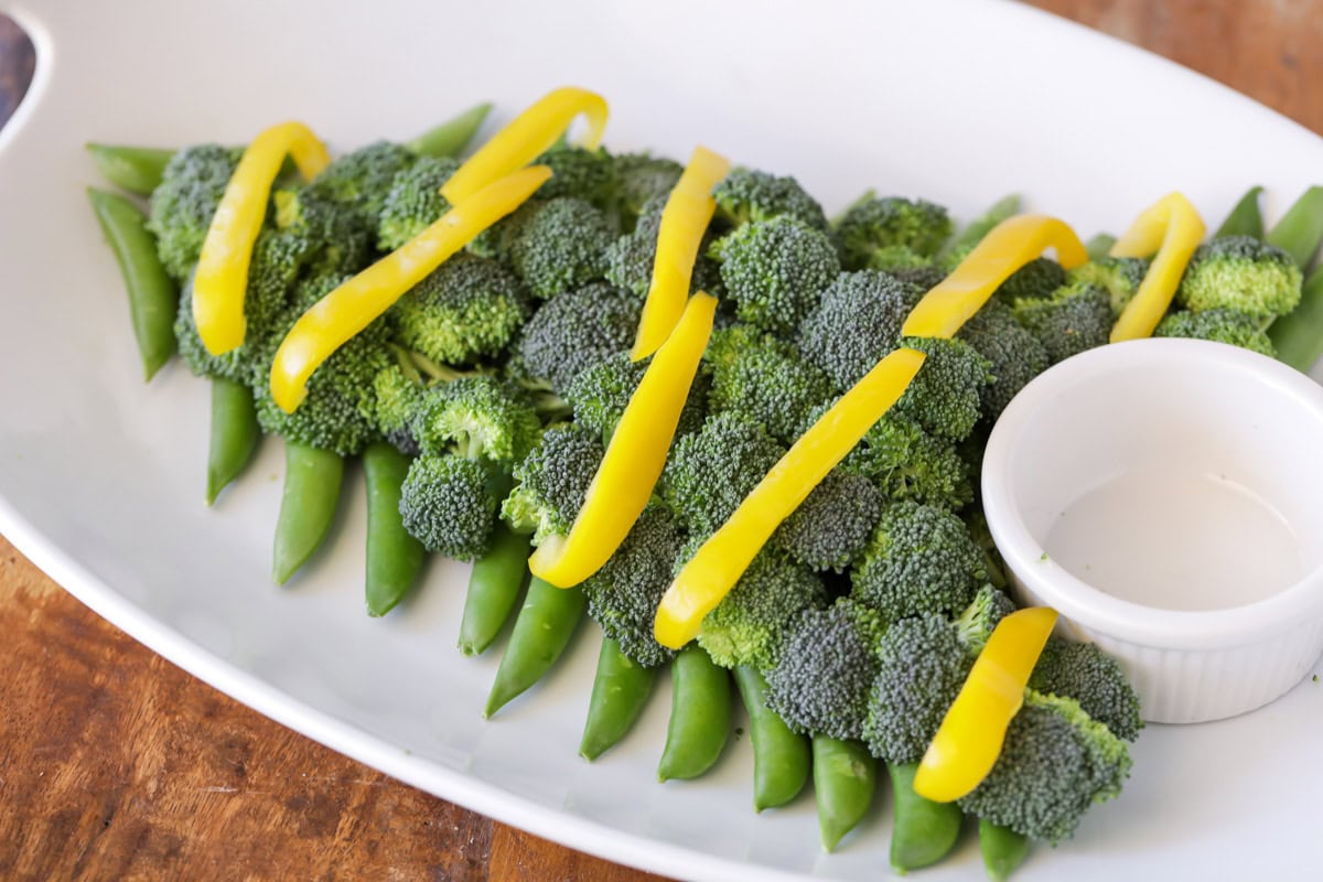 Adding pepper slices as garland to the veggie tree.