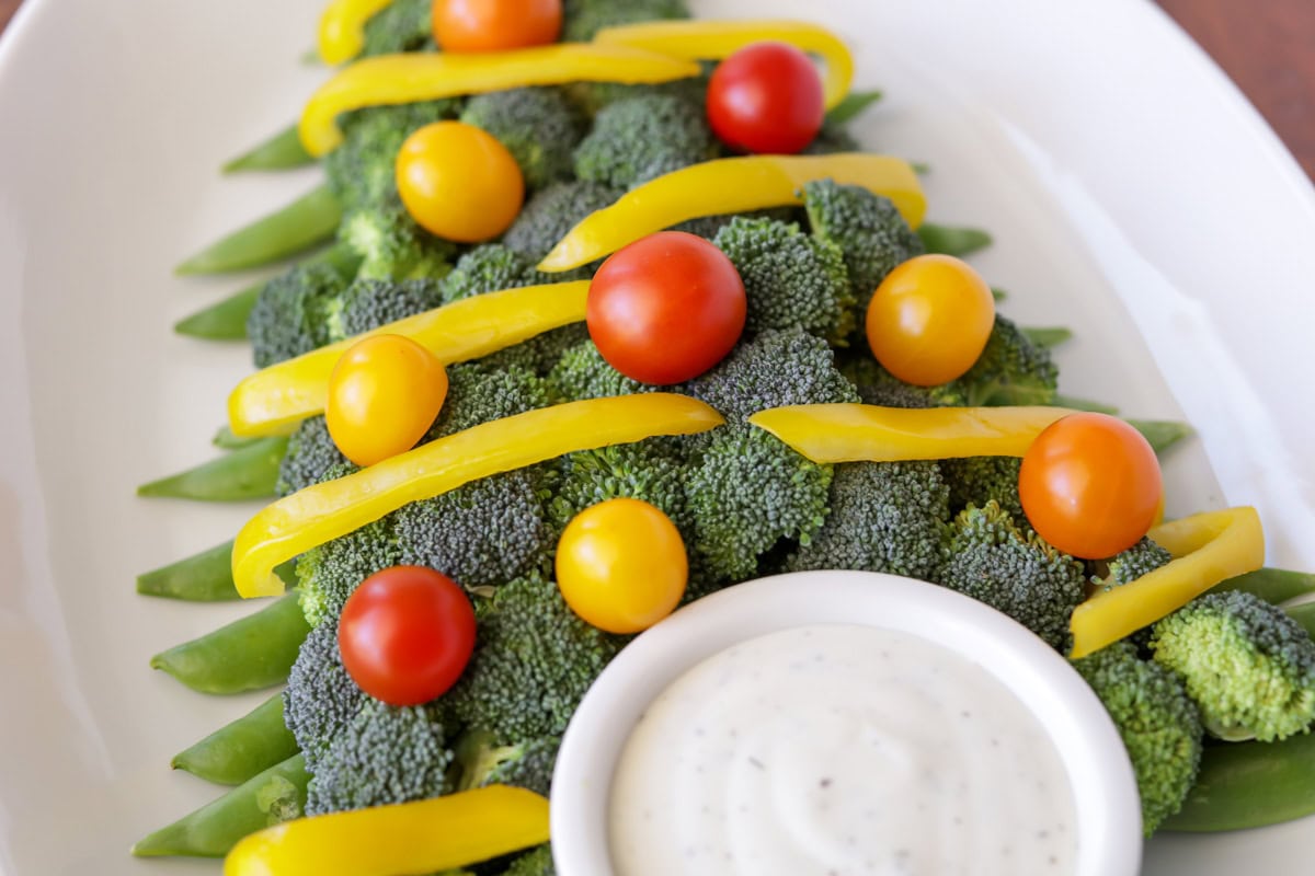 Adding tomatoes as ornaments to the veggie tree.