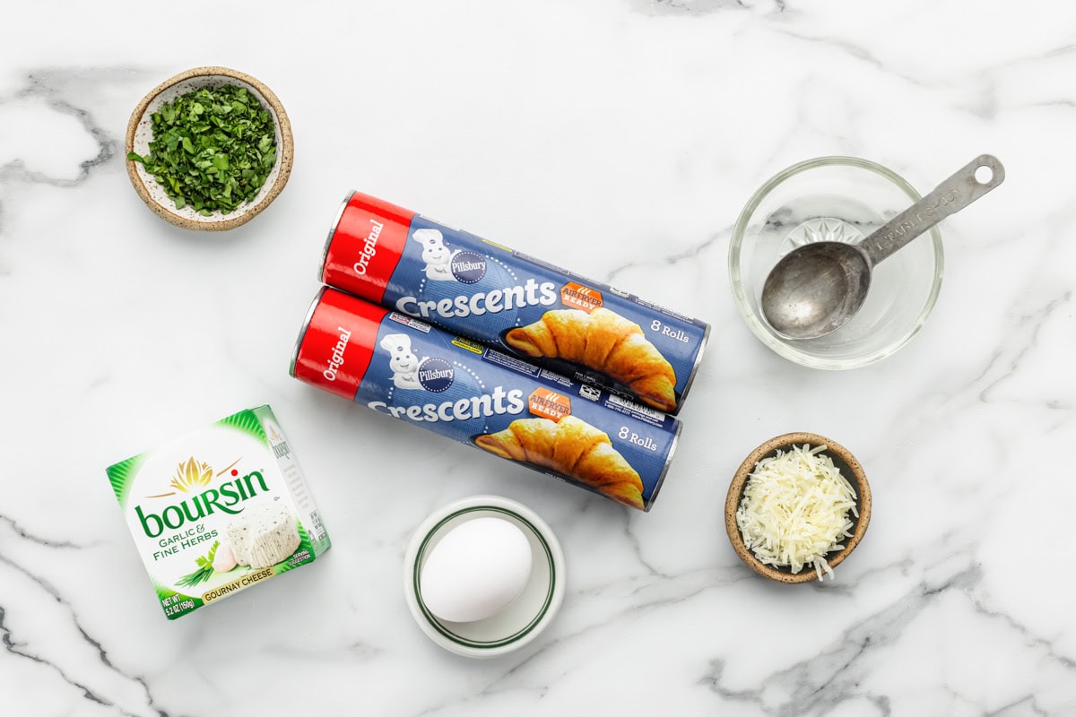 Crescent rolls, boursin cheese, and other ingredients on a kitchen counter.