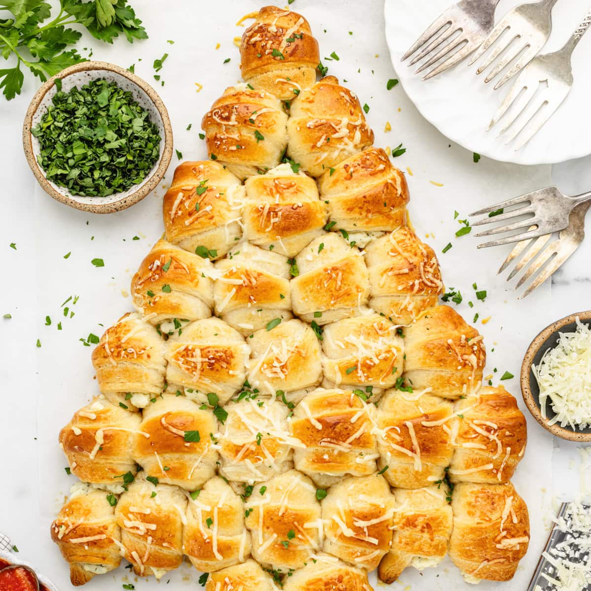 A crescent roll Christmas tree topped with fresh herbs.