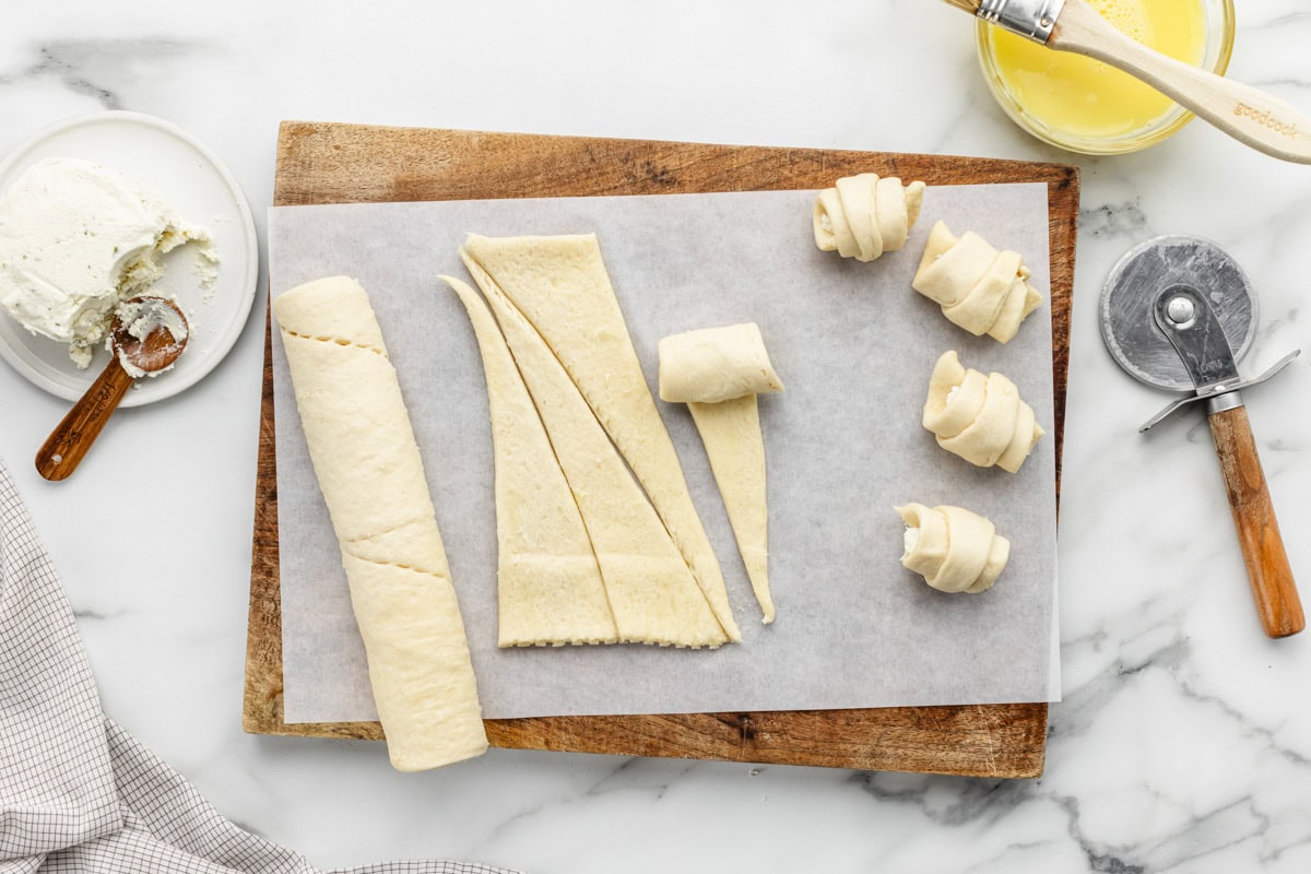 Rolling the crescent rolls filled with cheese.