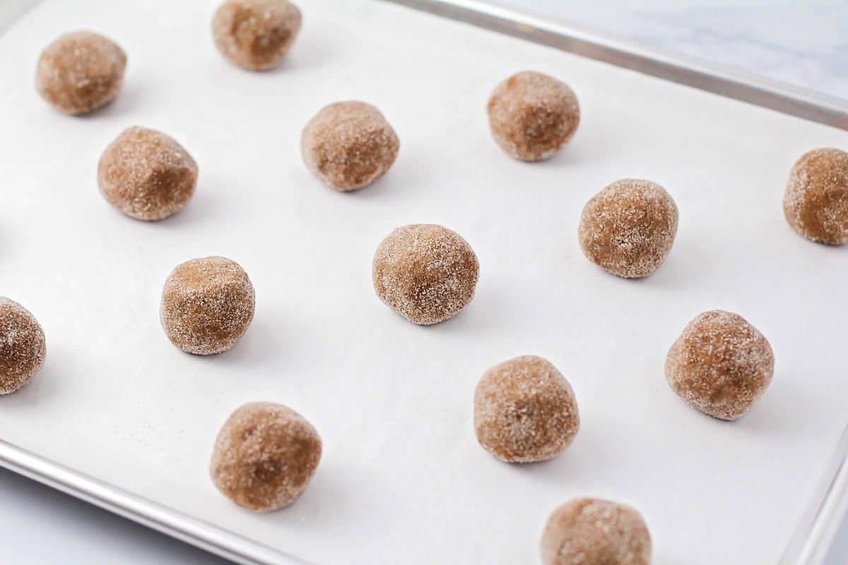 Dough ball rolled in sugar on a cookie sheet.