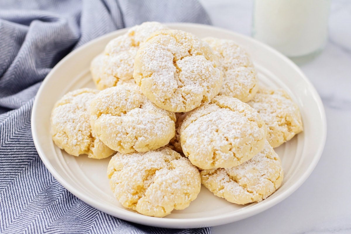 Gooey butter cookies recipe stacked on top of each other on white plate.