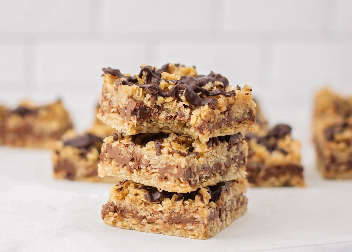 No Bake Chocolate Oat bars stacked on top of each other with bite taken out.