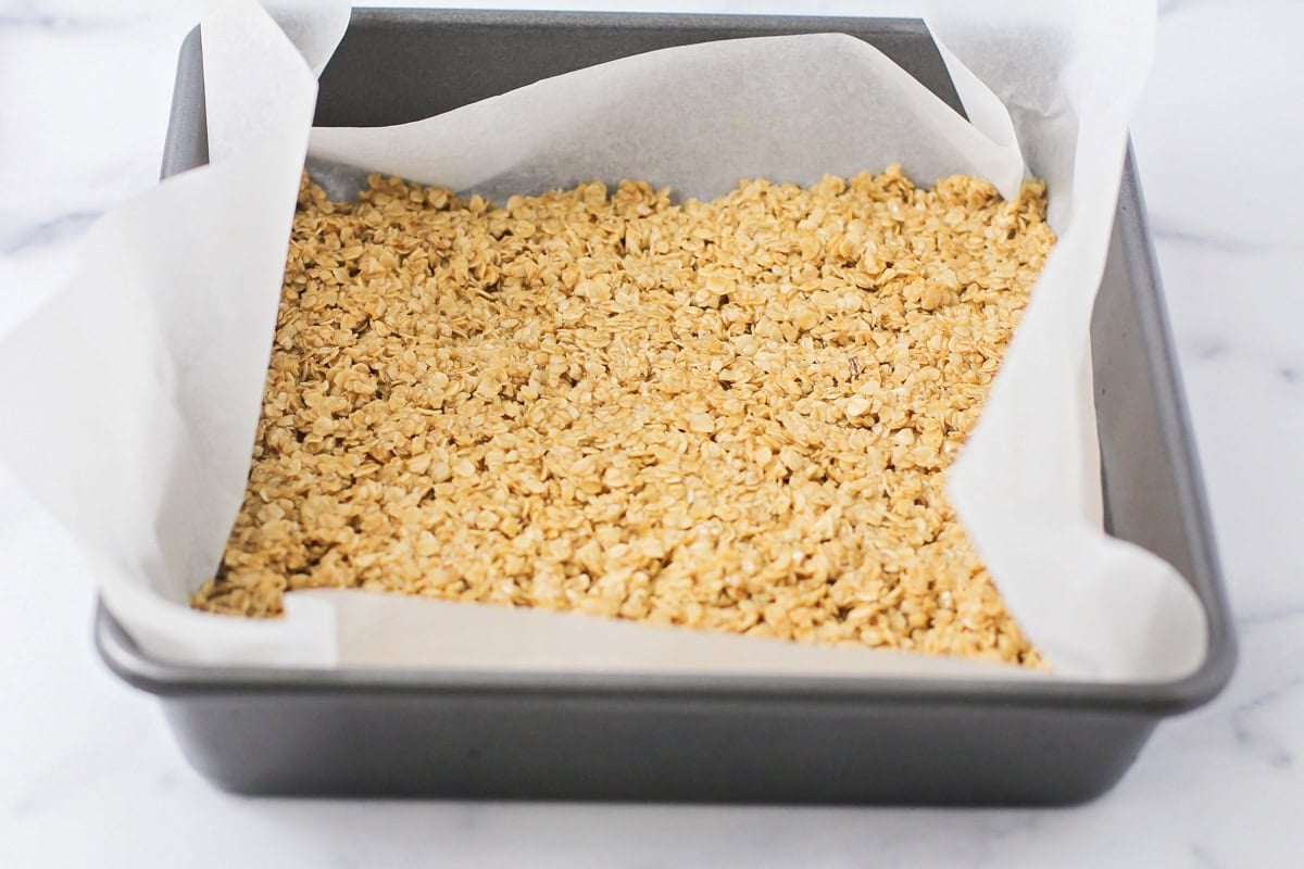 Oats pressed into the bottom of a baking dish.