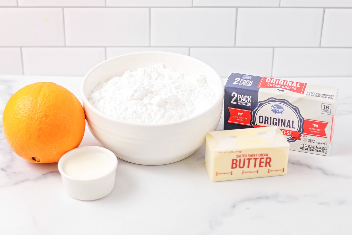 Filled with orange zest and smothered in an irresistible lemon frosting, these orange rolls are citrus-sweet roll heaven! Ingredients for sweet roll glaze on a kitchen counter.
