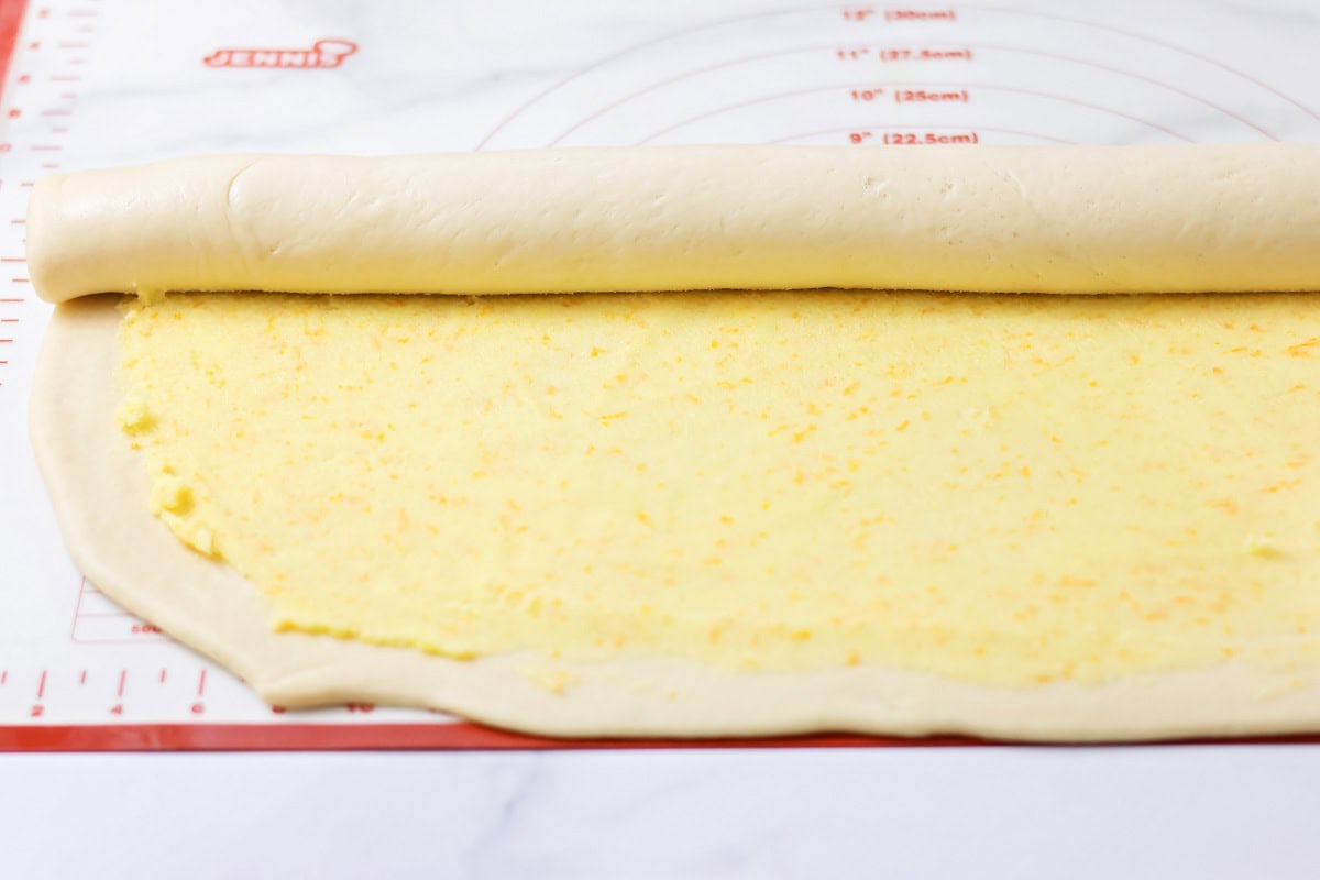 Filled with orange zest and smothered in an irresistible lemon frosting, these orange rolls are citrus-sweet roll heaven! Rolling dough into sweet rolls.