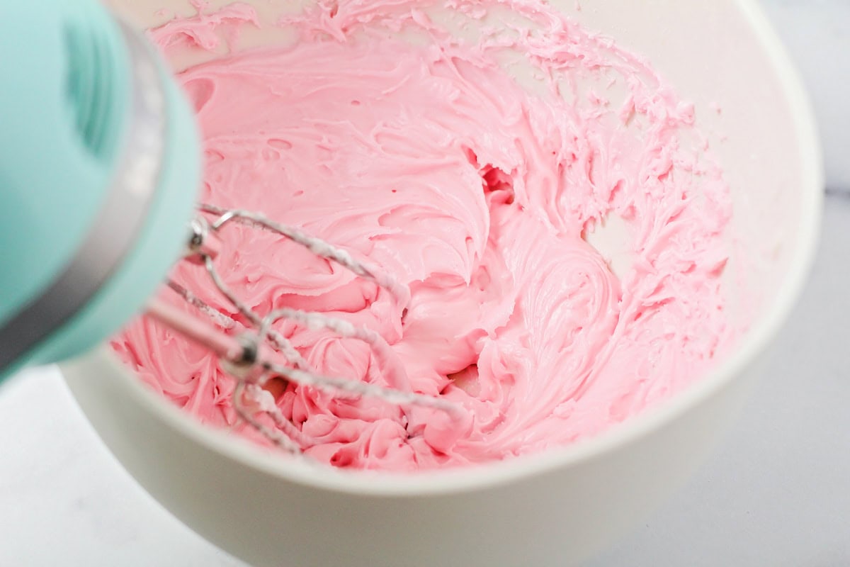 Pink peppermint frosting in a mixing bowl.