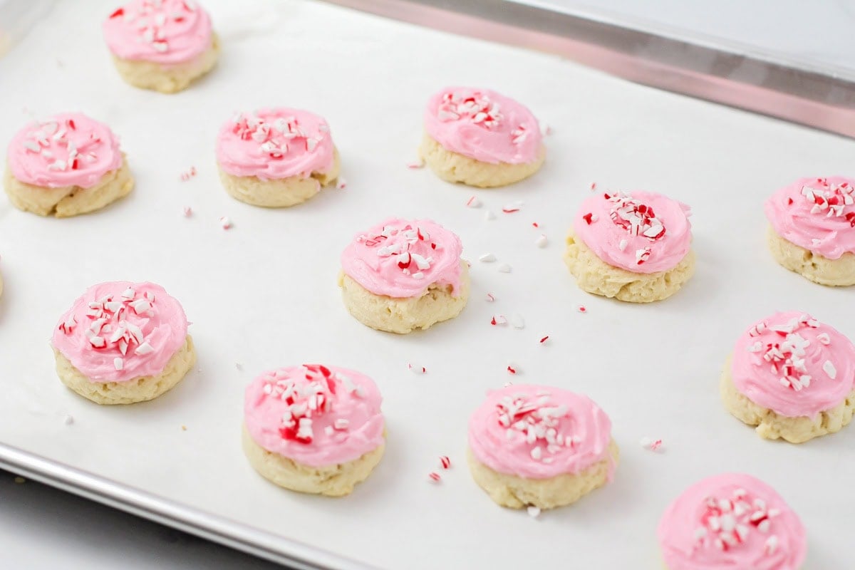 Baked cookies frosted and topped with crushed candy canes.